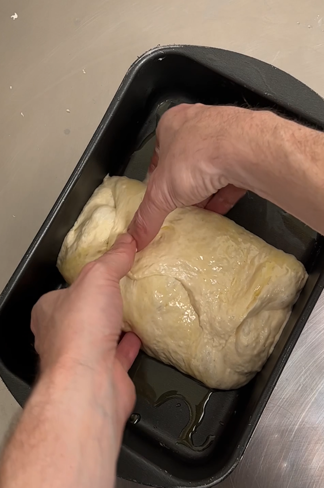 Now turn the dough upside down and by 90 degrees so that its long side is parallel to the long side of the pan